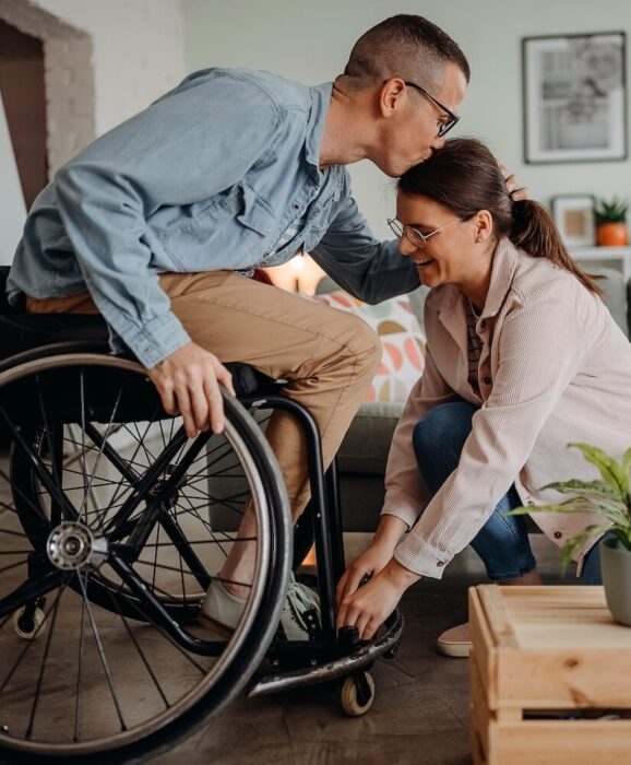 Person in Wheelcare kissing partner on forehead aspect ratio 303 367 1