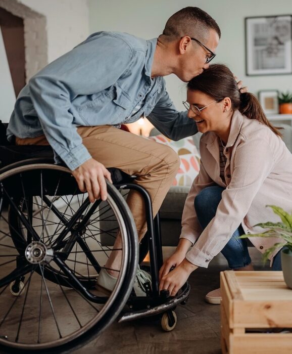 Person in Wheelcare kissing partner on forehead aspect ratio 303 367 2