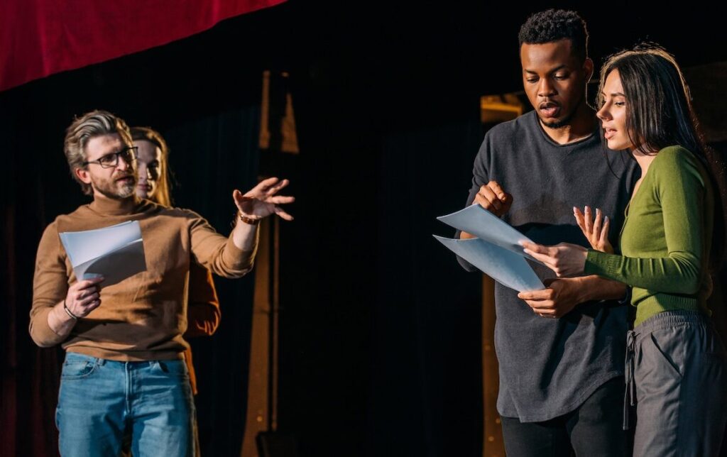Two Actors on Stage with Director