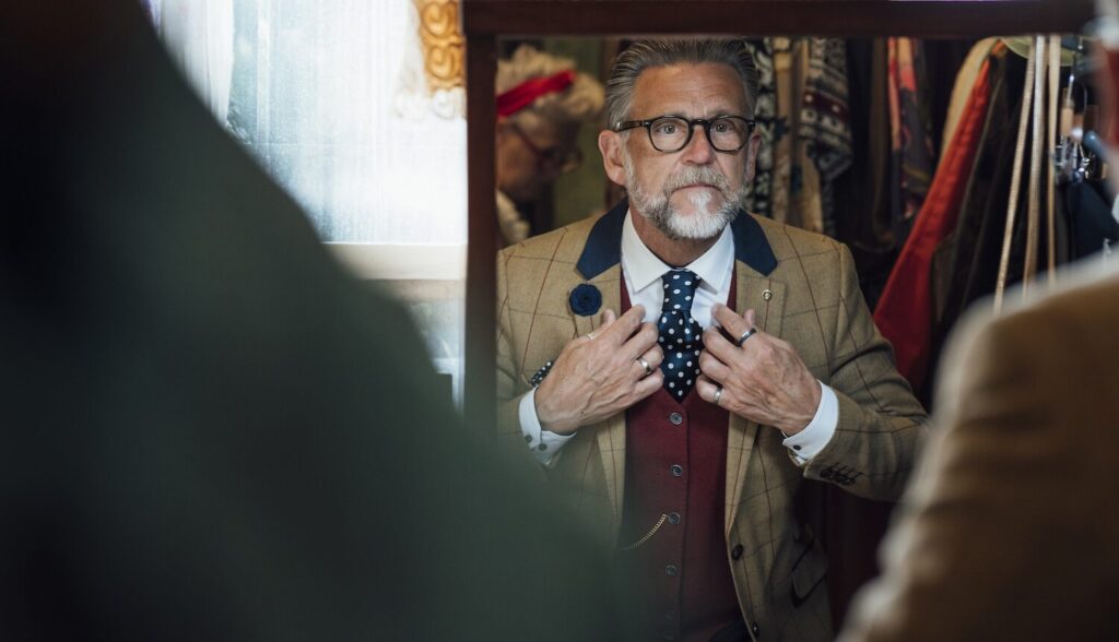 Older-Gentleman-with-Costume-in-Mirror-aspect-ratio-564-324