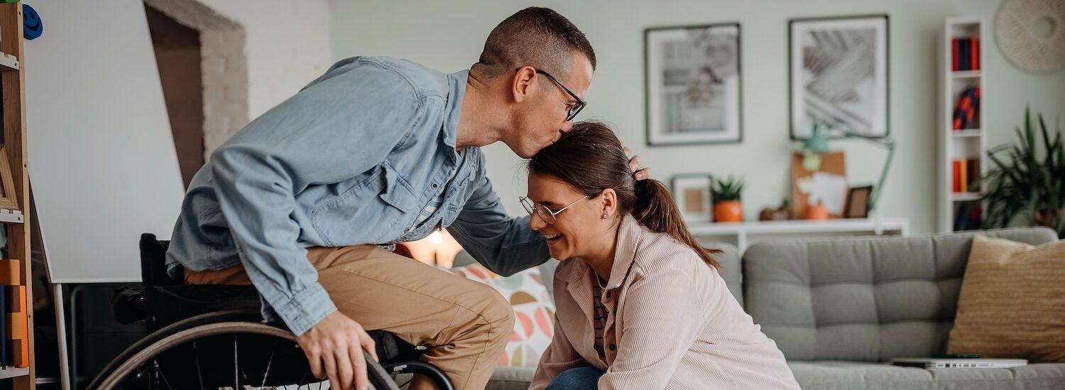 Person-in-Wheelcare-kissing-partner-on-forehead-aspect-ratio-1512-554