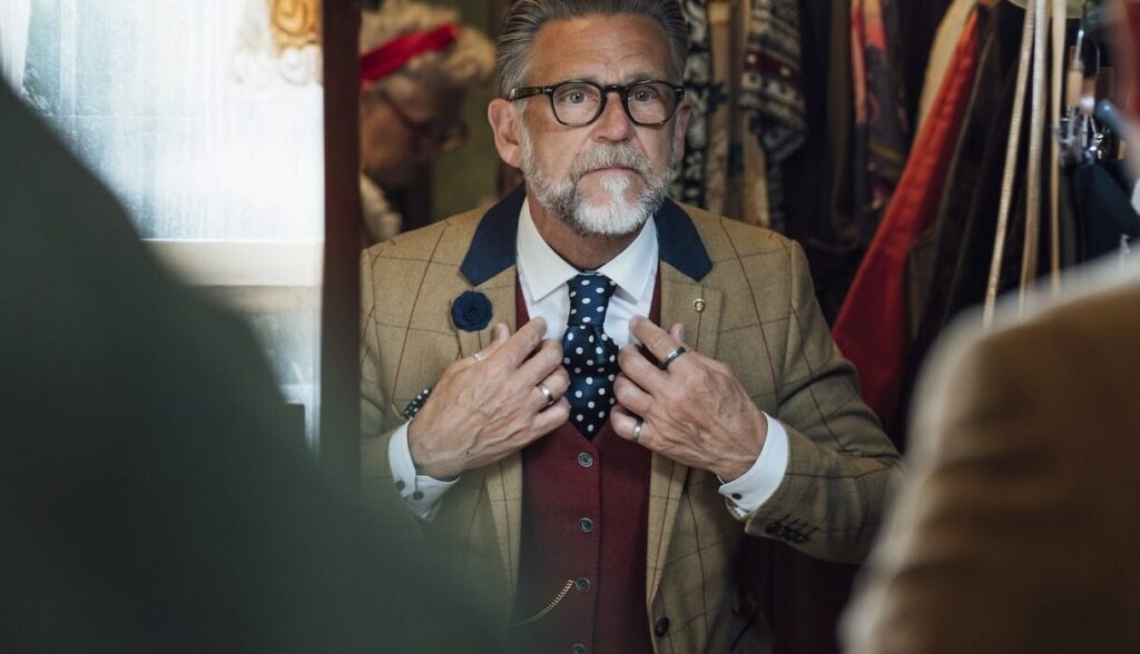 Older-Gentleman-with-Costume-in-Mirror-aspect-ratio-564-324